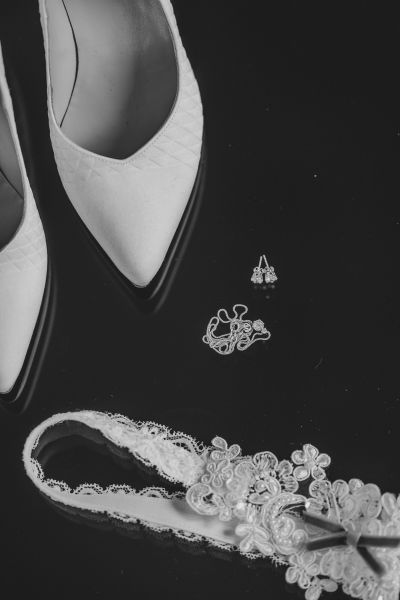 Detailaufnahme von Brautschuhen und Spitzenstoff – künstlerisches Schwarz-Weiß-Foto.