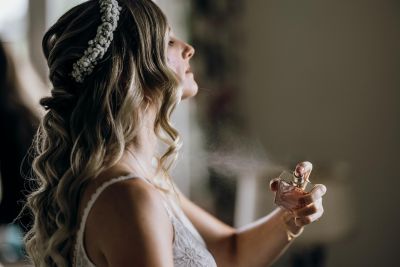 Braut sprüht Parfüm auf, während sie sich vorbereitet – eleganter Moment beim Getting Ready.