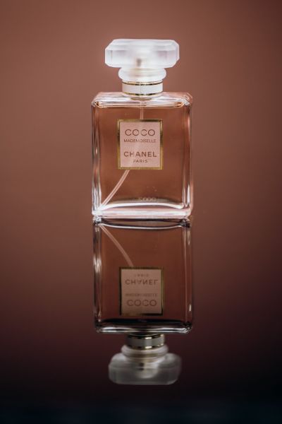 Flakon des Parfüms „Coco Mademoiselle Chanel“ auf reflektierender Oberfläche – stilvolles Detailbild.